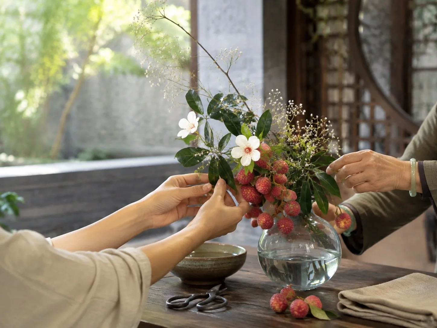 Hands pruning a branch over a traditional vessel during a Lingnan flower-arranging session